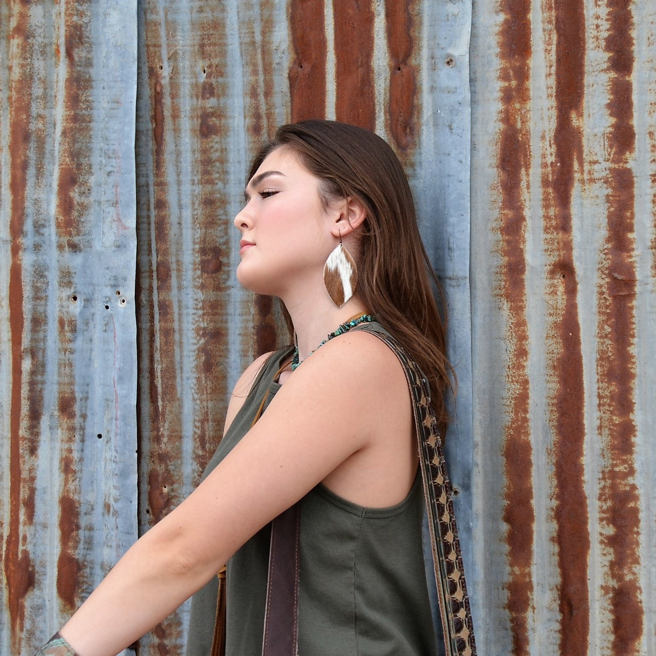 Women Wearing Leather Oval Earrings in Tan and White Hair on Hide